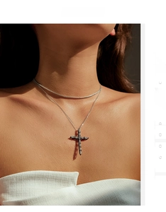 Detail of S925 silver layered necklace with black cross pendant on model neck