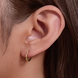 Minimalist 925 sterling silver golden bamboo hoop earrings worn on a female ear