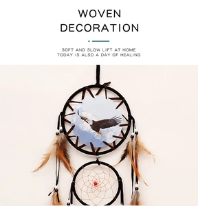 Detail of woven dream catcher with eagle pattern, natural feathers, and dark beads