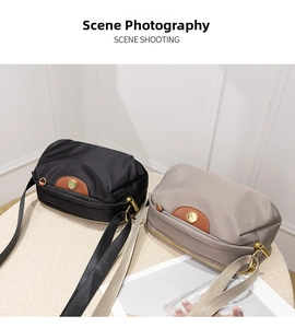 Detail of oxford cloth crossbody bags in black and taupe with brown leather zipper pulls