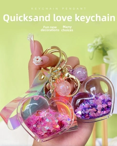 Detail of pink and purple liquid heart keychains with sparkling sequins and laser straps