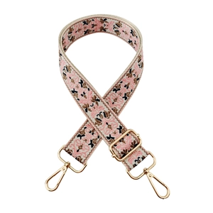Pink and brown floral jacquard bag strap with golden metal swivel hooks on white backdrop