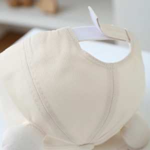 Close-up of beige cotton baseball cap with white Velcro adjustable back strap detail