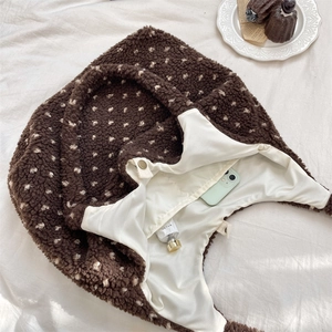 Close-up of brown sherpa heart tote bag with white polka dots and metal snap button
