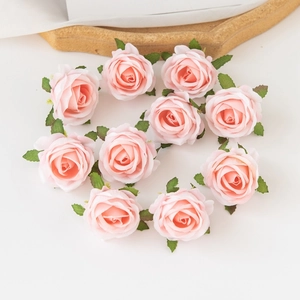 Diez cabezas de rosas de seda artificial rosa dispuestas sobre fondo blanco