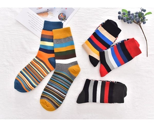 Detailed view of colorful striped cotton socks for men in various rolling styles