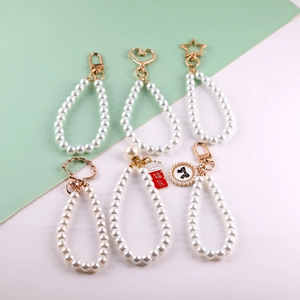 Detailed macro view of assorted glass pearl phone lanyards with various gold metal charms