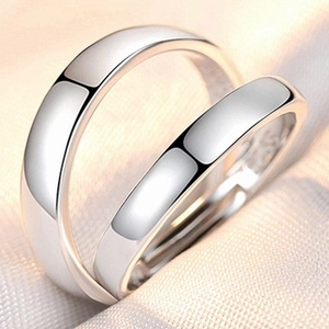 Close-up of minimalist silver plated adjustable rings on soft beige textile background