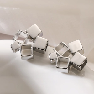 Pendientes geométricos de plata con forma cuadrada sobre seda suave para un look chic