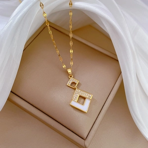 Detail of gold geometric square pendant necklace with micro-pave zircons and white inlay