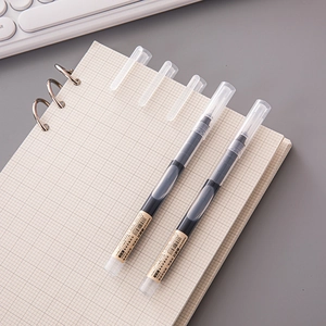 Macro detail of 0.5mm quick-dry liquid ink pens on a grid notebook for office use