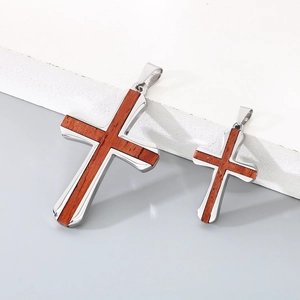 Détail de pendentifs croix en acier bicolore avec incrustation en bois de poirier rouge massif
