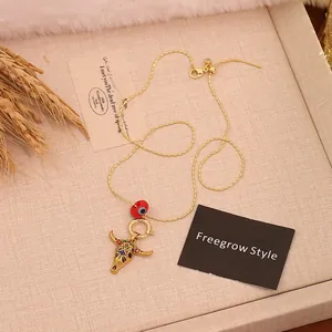 Detail of bohemian gold chain necklace with colorful bull head pendant and evil eye bead