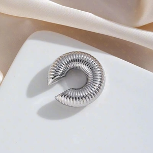 Silver stainless steel C-shaped earrings with textured pleats on a cream silk background