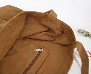 Detail view of the brown canvas tote bag interior showing the zippered inner pocket