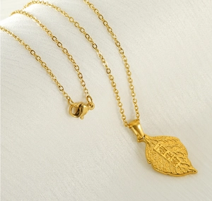 Vue détaillée du pendentif feuille en or 18k avec caractères chinois sur fond soie