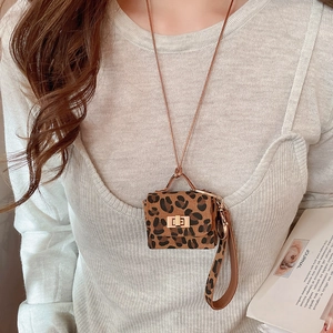 Macro shot of mini leopard print pendant bag with golden buckle on knitted sweater