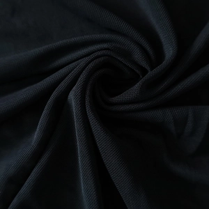 Gros plan du tissu en maille noire montrant le tissage fin d'une robe moulante