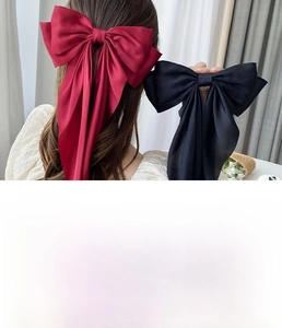 Detailed view of handmade large satin bow hair clips with long elegant ribbons in various colors