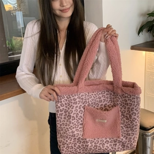 Detail of pink leopard print tote bag featuring plush faux fur trim and front pocket design