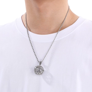 Close-up of a silver hollow sphere pendant with star patterns on a twist chain