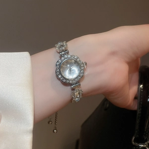 Close-up of elegant flower-shaped silver watch with sparkling rhinestones on female wrist