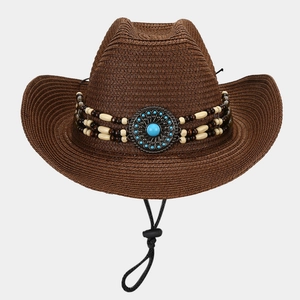 Detail of a brown woven straw sun hat with ethnic bead bands and turquoise metal ornament