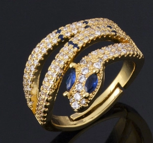 Gold snake ring with colorful zircon stones and blue gems on black background