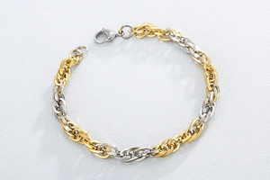 Detail of two-tone gold and silver braided chain bracelet with lobster clasp