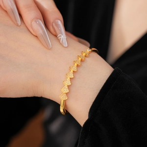 Detail showing gold fan-shaped links set with white zircons on a delicate bracelet