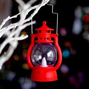 Retro red LED Halloween lantern hanging on white branches with festive bokeh light background