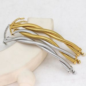 Detail of twisted woven steel bracelets in gold and silver finish with lobster clasp