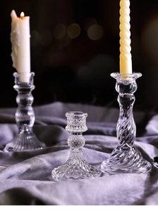 Detailed view of three vintage glass candle holders with textured patterns on grey fabric