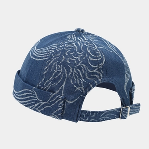 Detail of blue denim docker hat featuring white embroidery and adjustable metal back strap