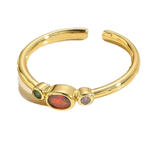 Adjustable gold ring featuring oval red zircon with green and purple side stones