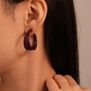 Close-up of retro burgundy multi-layered C-shaped earrings with fine wire-wrapped texture