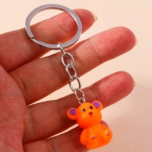 Detail of cute orange bear keychain with purple glitter ears and silver metal ring