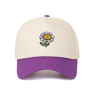 Detail of sunflower smiley face embroidery on a two-tone cotton baseball cap