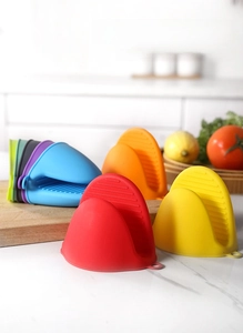 Detail of colorful silicone oven mitts with anti-slip ridges on a kitchen countertop
