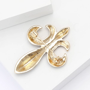 Detailed back view of golden fleur-de-lis brooch showing clasp and pin mechanism