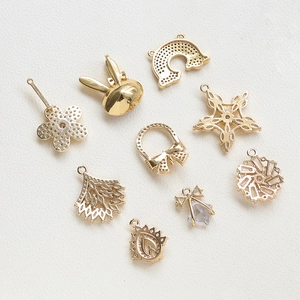 Close-up of gold-plated DIY pendants with star, flower, and rabbit shapes with cubic zirconia