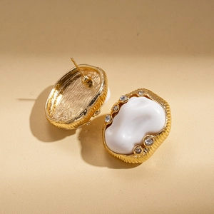 Vintage gold and white acrylic oval stud earrings with pleated texture and rhinestones