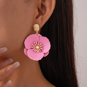 Close-up of pink layered flower earrings with a pearl center and golden metallic stud