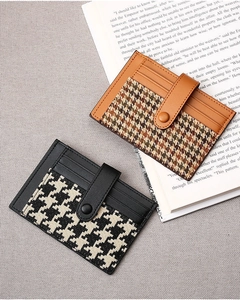 Detail of slim houndstooth card holders with snap button closure on vintage book