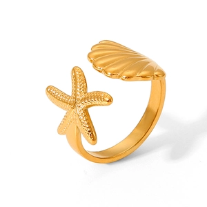 Gold starfish and shell open ring detail with metallic texture on white background
