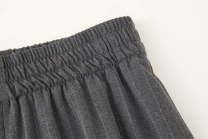 Détail macro du pantalon gris foncé à fines rayures avec taille élastique plissée