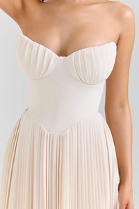 Detail of elegant off-shoulder beige pleated dress showing bust cup and waistline