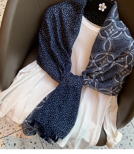 Detailed texture of dark blue linen scarf with white polka dots and vintage patterns