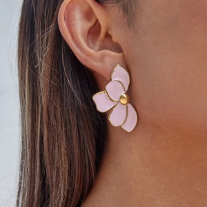 Nahaufnahme von rosa Emaille-Blumenohrring mit 18K Goldrand am Ohr eines Models