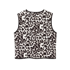 Detail of quilted leopard print vest back featuring black binding and contrast piping